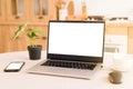 Front view of laptop with white screen in a kitchen with soft and warm light.help in the kitchen with new technologies.isolation Royalty Free Stock Photo