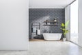 Front view on light grey wall with place for poster in modern bathroom with white bath on grey brick wall background, concrete and Royalty Free Stock Photo