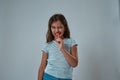 Front view of little girl biting sweet lollipop Royalty Free Stock Photo