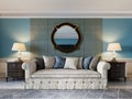 Front view of a luxurious beige sofa in a classic style with two wooden bedside tables with lamps and a mirror on a light blue