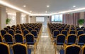 Front view of luxury auditorium interior with empty white screen. Modern conference hall with rows of vintage blue, golden chairs Royalty Free Stock Photo