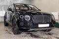 Front view of luxury very expensive new black Bentley Bentay car stands in the washing box waiting for repair in auto service Royalty Free Stock Photo