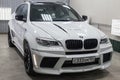 Front view of luxury very expensive new white BMW X6 M Lumma CLR tuning car stands in the washing box waiting for repair in auto