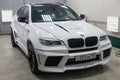 Front view of luxury very expensive new white BMW X6 M Lumma CLR tuning car stands in the washing box waiting for repair in auto