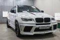 Front view of luxury very expensive new white BMW X6 M Lumma CLR tuning car stands in the washing box waiting for repair in auto