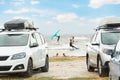 Front view many cars parked with surf board kite equipment on sand beach, van vehicle with rooftop box ocean sea beach Royalty Free Stock Photo