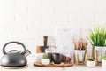 Front view of a marble countertop with kitchen utensils and houseplants in modern pots. white brick background of the wall. a copy Royalty Free Stock Photo