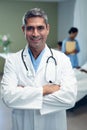 Male doctor standing with arms crossed in the ward at hospital Royalty Free Stock Photo