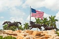 American flag and two running horse statues