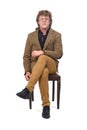 A front view of middle aged man with blazer sitting on chair on white background Royalty Free Stock Photo