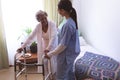 Female nurse helping senior female patient to stand with walker Royalty Free Stock Photo