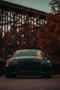 Front view of a modern black Audi RS5 on the street during an autumn sunset.