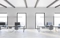 Front view on modern comfortable workplace in spacious coworking office with marble floor, minimalistic furniture and city view