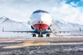 Front view of the modern corporate business jet with open gangway door on the winter airport apron on the background of Royalty Free Stock Photo