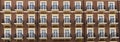 Front view of a modern residential brown brick building with balconies and Windows, close-up, pattern Royalty Free Stock Photo