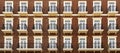 Front view of a modern residential brown brick building with balconies and Windows, close-up, pattern Royalty Free Stock Photo