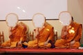 Front view of monks holding talipot fan and praying on the seat at the temple.