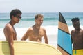 Male friends standing and holding surfboard at beach Royalty Free Stock Photo