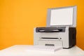 Front view of a multifunctional device - printer,copier,scanner and a stack of blank sheets of A4 paper on a white table Royalty Free Stock Photo