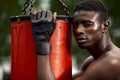 Front view of muscular black boxer punching towards camera with a deep and intense face outdoor. Boxing and Training Royalty Free Stock Photo