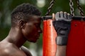 Front view of muscular black boxer punching towards camera with a deep and intense face outdoor. Boxing and Training Royalty Free Stock Photo