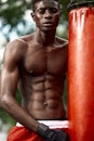 Front view of muscular black boxer punching towards camera with a deep and intense face outdoor. Boxing and Training Royalty Free Stock Photo