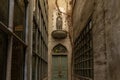 Front view of narrow alley entrance of ancient church with wooden door and stone woman statue Royalty Free Stock Photo