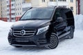 Front view of new a expensive Mercedes Benz V-class minivan bumper and hood of a car, a long black limousine, model outdoors, Royalty Free Stock Photo