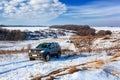 Front view of Offroad car climbing winter hill