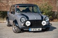 Front view of an old classic Mini Cooper in gray color on the street