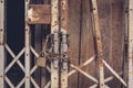 The front view old gold steel lock and damaged and rusted steel door on wooden door