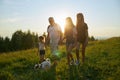 Man with girls and dog going forward in hills. Royalty Free Stock Photo