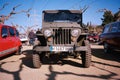 Front view of an old Willys Jeep MB military all-terrain truck parked near other cars