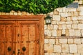 front view on old wooden door, brick wall and green ivy Royalty Free Stock Photo