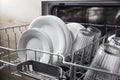 Open dishwasher with clean utensil inside, cutlery, glasses, dishes at kitchen Royalty Free Stock Photo