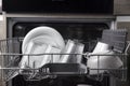 Open dishwasher with clean utensil inside, cutlery, glasses, dishes at kitchen Royalty Free Stock Photo