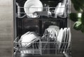 Open dishwasher with clean utensil inside, cutlery, glasses, dishes at kitchen Royalty Free Stock Photo