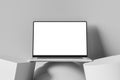 Front view of an open laptop with a blank screen, placed on an abstract shapes. Minimalistic and clean workspace with a neutral