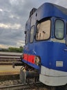 Front view and part of the side of a beautiful old train parked in the station. In the background, empty tracks and a blue sky Royalty Free Stock Photo