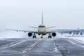 Front view of the passenger airliner taxiing on taxiway in snowy winter day Royalty Free Stock Photo