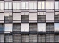 Front view pattern of windows or glazed casement on a modern building with lowered blinders or curtains to stop the sun