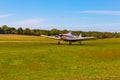 The front view of the tail, body, wings, nose and propeller of Piper PA-25 Pawnee tow aircraft on the ground.