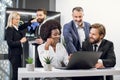 Front view of pleasant happy confident mixed race business colleagues, African lady and two Caucasian men, working Royalty Free Stock Photo