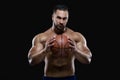 Front view portrait of an attractive sportsman holding a basketball with both hands isolated on black background Royalty Free Stock Photo