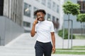 Front view portrait of attractive woman with mobile phone looking away and laughing on city street Royalty Free Stock Photo