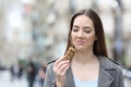 Disgusted woman looking at snack bar on city street