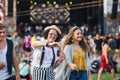 Front view portrait of group of young friends dancing at summer festival. Royalty Free Stock Photo