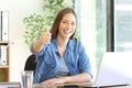 Happy freelance worker gesturing thumbs up at office