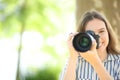 Happy photographer taking photos looking at you in a park Royalty Free Stock Photo