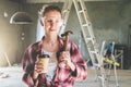 Front view. Portrait of happy young female construction worker, carpenter, repairman standing in workshop Royalty Free Stock Photo